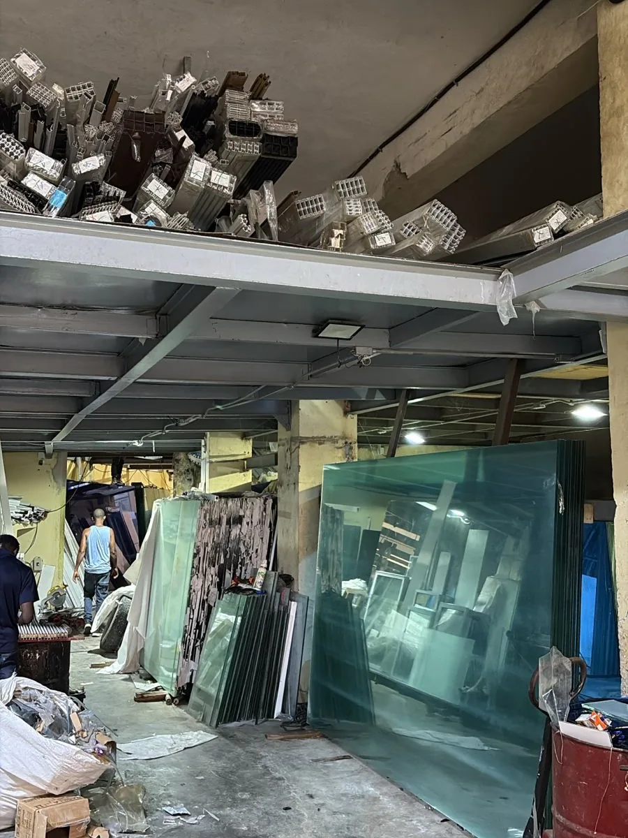 Perfiles de aluminio almacenados en el entrepiso y láminas de vidrio en el local